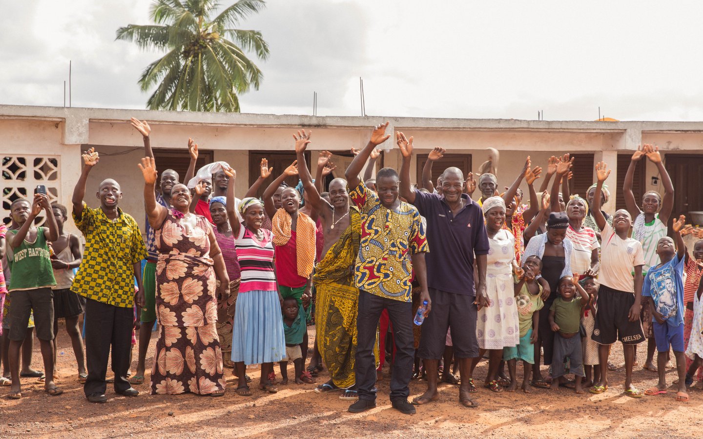 A group of people hold up their hands and smile