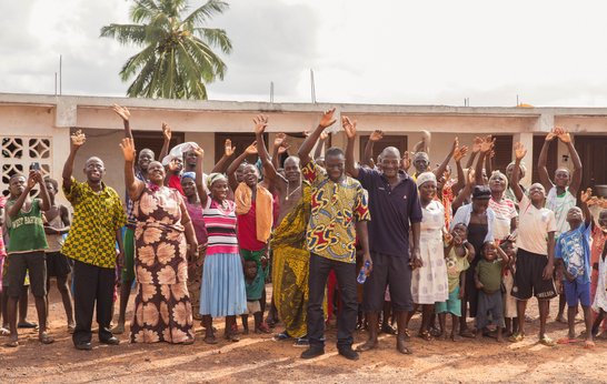 A group of people hold up their hands and smile