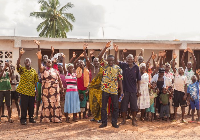 A group of people hold up their hands and smile
