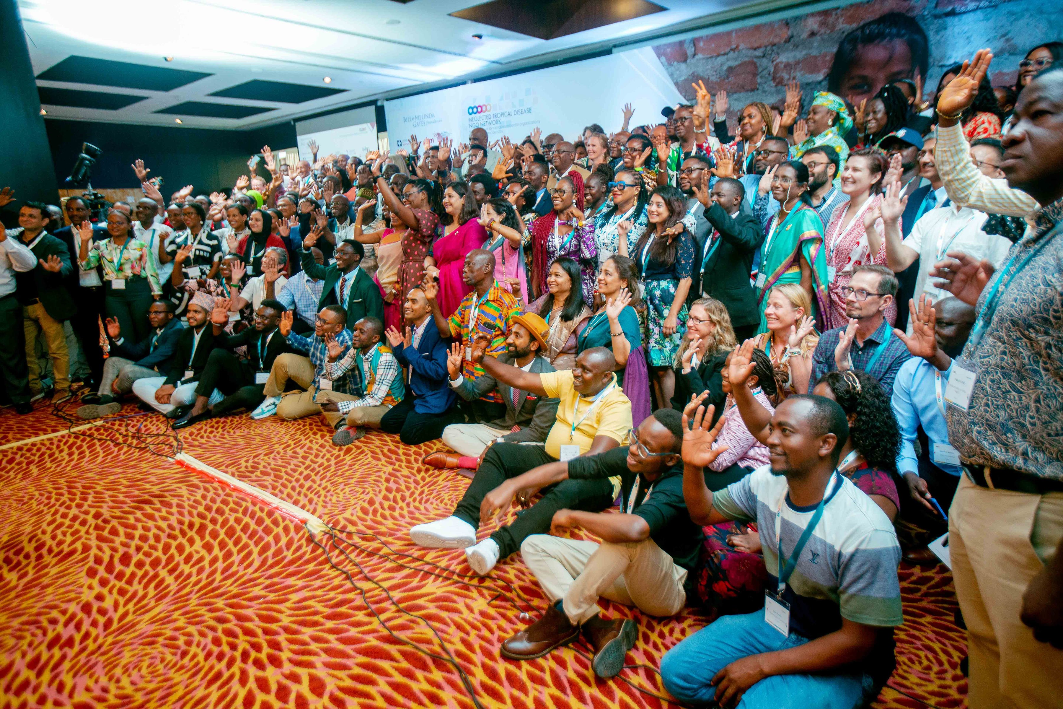 All delegates at the NNN conference 2023, smiling and raising their arms to camera
