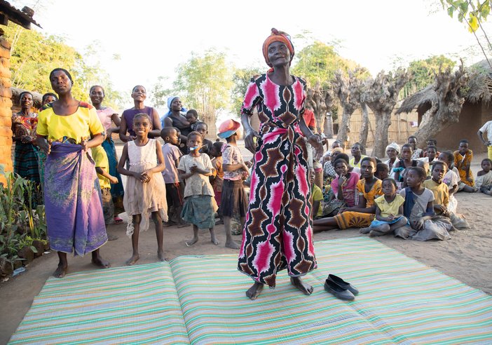 Community members in Salima, Malawi welcome four All Party Parlimentarian Group (APPG) on Malaria and NTDs Parliamentarians, as they visit a patients home.
