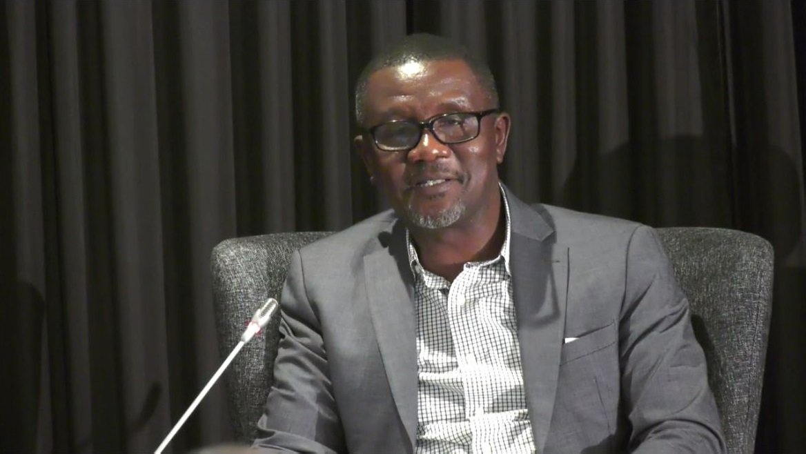 Aggrey Aluso speaks at a lectern